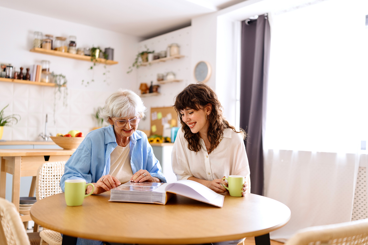 Senior woman and her grandchild looking at the old photo album memory care in Phoenix